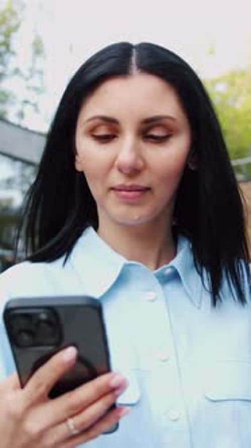 Young Woman Wearing Casual Clothes Using a Mobile Phone and Holding a Laptop Walking and Relaxing in