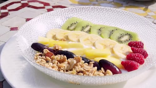 Delicious and healthy breakfast plate with fruit and nuts outside on a sunny day