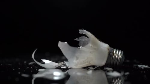 Glass pieces of broken bulb of incandescent lamp with tungsten wire, energy efficient concept