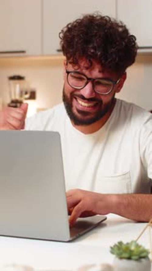 Man Working on Laptop at Home, Celebrates Success