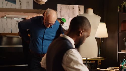 Un vieux client essaie une veste de costume
