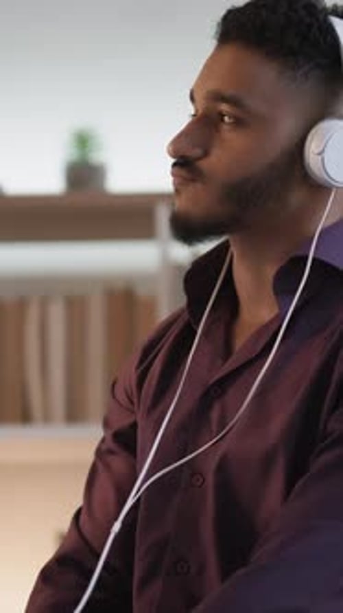 Young Adult Listening to Music and Drinking Beverage