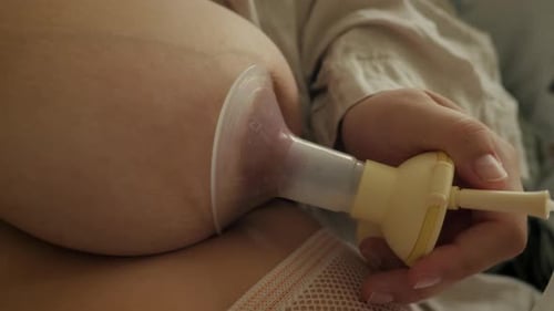 Mutter sammelt Milch mit der Milchpumpe. Ideal zur Sensibilisierung für Eltern, Mutterschaft und Stillen