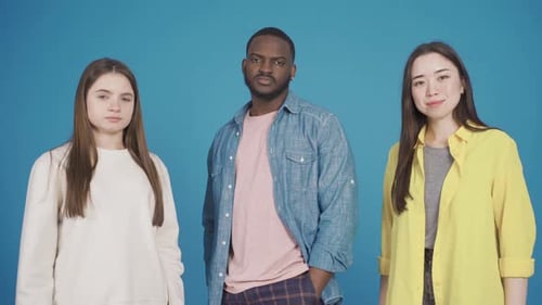 Young Adults Posing in Studio with Blue Backdrop