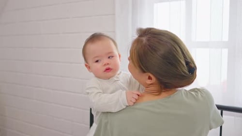 Mother Comforting Infant at Home in the Daytime