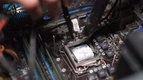 Closeup of Unrecognizable Gamer Male Removing Dust Buildup on Motherboard Using Brush and Vacuum