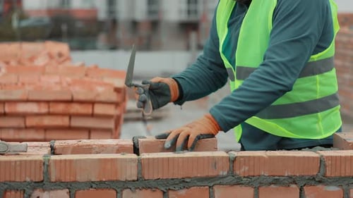 Construction Worker Laying Bricks on a Wall Closeup of a Construction Worker Building a Brick Wall