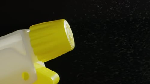Junger Mann, der im Dunkeln Parfüm auf die Haut aufträgt, Nahaufnahme des Sprühens eines Deodorants, Luxus-Parfüm