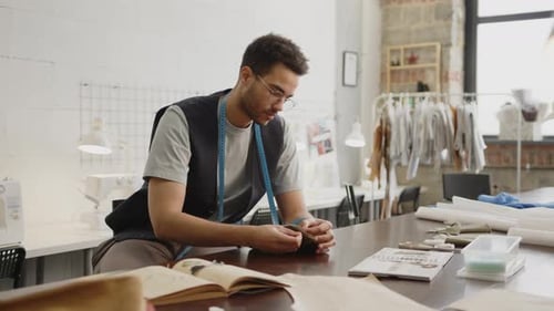 Tailor Hand Sewing at Workplace in Atelier