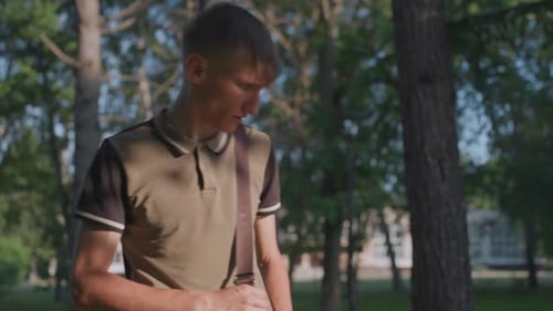 Un joven comprueba el contenido en Sunny Park Un hombre del parque examina y organiza los objetos dentro de su
