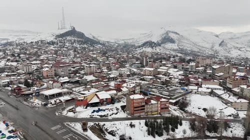 Snow Covered Town Center in Winter – Aerial Drone View of District with Mountains