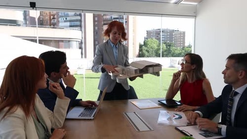 Business team taking a break with pizza in a modern office setting. Engaged in informal discussion w