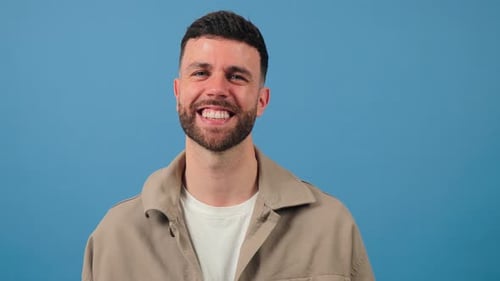 Smiling Young Man Portrait Against Blue Background