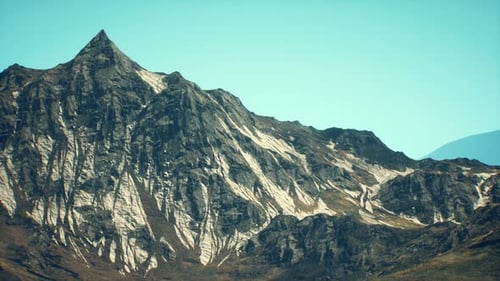 Majestic Mountain Peak Rising Against a Clear Blue Sky During Daytime