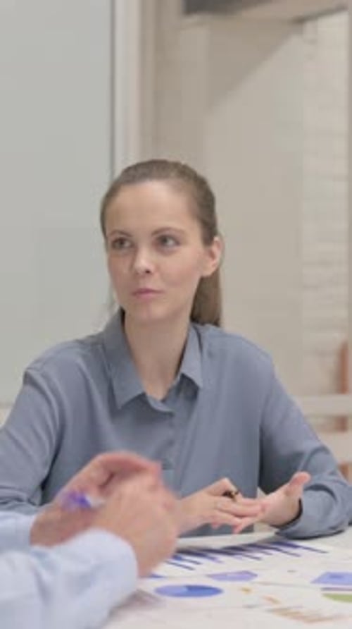 Woman Discussing Charts and Graphs at Office Meeting