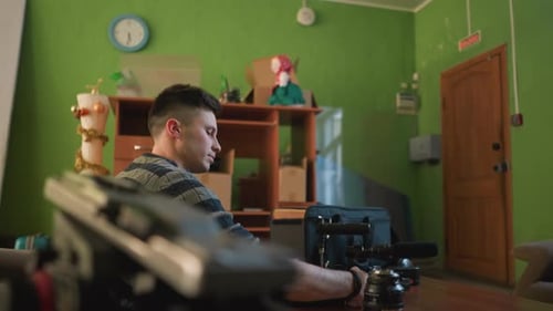 Young Man Assembling Camera Equipment Indoors