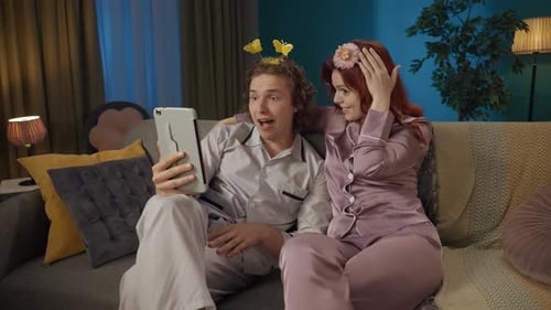 Couple Video Chatting on Tablet in Pajamas at Home