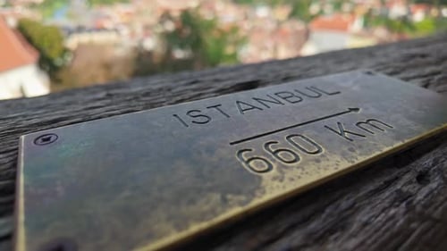 Close-up of a metal plaque indicating the distance to Istanbul from the Clock Tower in Sighișoara.