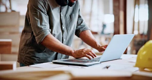 Hands, carpenter and typing on laptop in workshop for woodwork order, design review and inventory