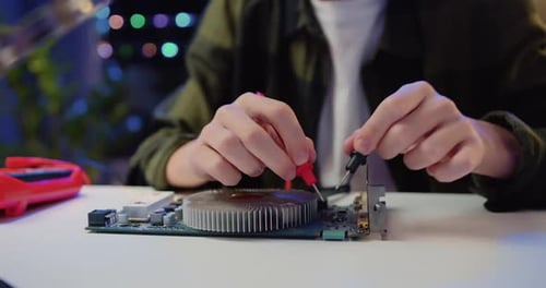 Close Up. Engineer Soldering Microcircuit. Unknown Male Hands with a Tool Repairs a Home Electronic