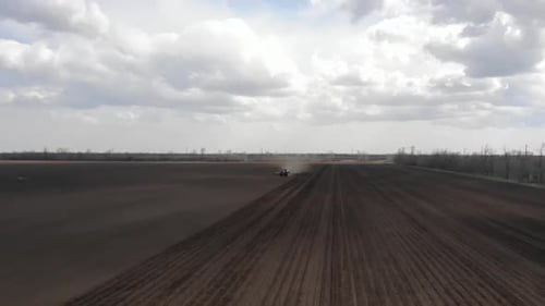 Blue tractor working on the field in Odessa in Ukraine during planting sunflower
