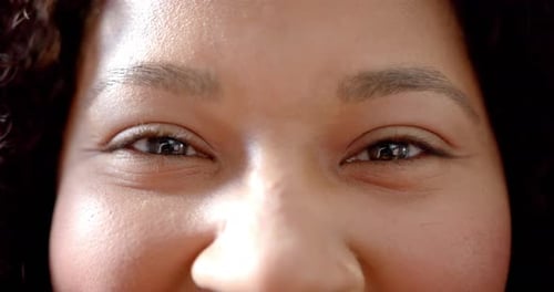 Portrait close up of eyes of happy african american woman smiling, slow motion