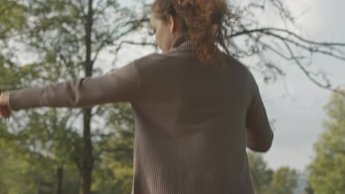 Young Woman with Dog Running in Park