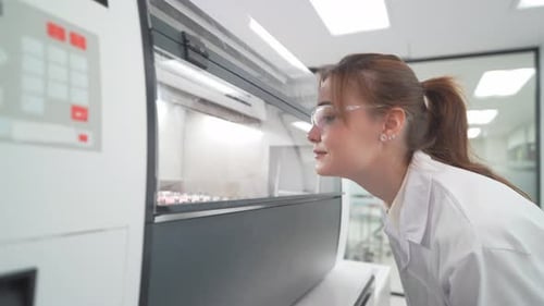 Woman Scientist Inspecting Lab Equipment in Clean Room