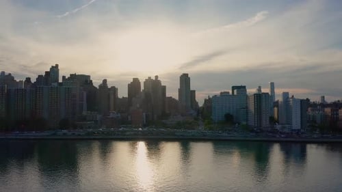 pan of the Manhattan New York City skyline from the East River at sunset. Gorgeous reflection