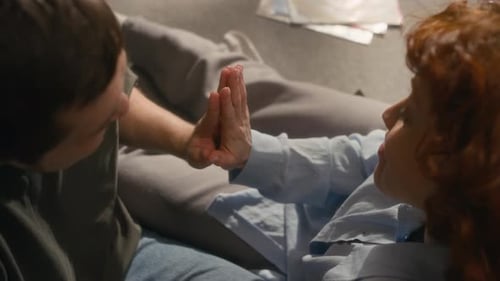 Couple Touching Hands on Floor