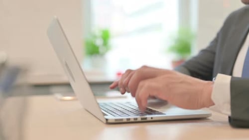 Close Up of Male Hands Typing on Laptop Keyboard at Work
