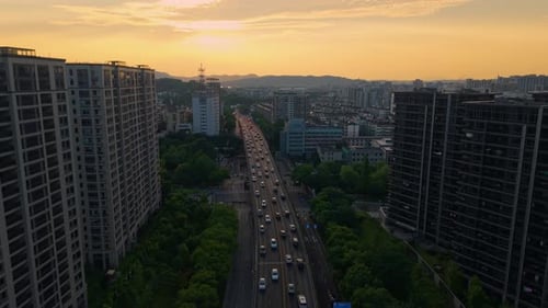Luftaufnahme der geschäftigen Stadtinfrastruktur bei Sonnenuntergang mit Bergen im Hintergrund China