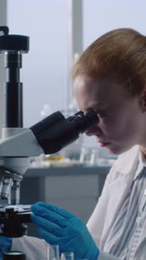 Scientist Using Microscope in Medical Laboratory