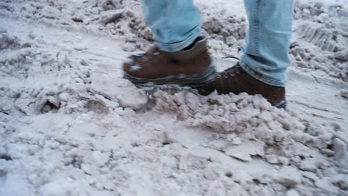 Person Walking on Snowy Path in Winter City
