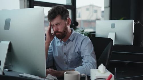 Un homme concentré engagé dans un travail de bureau moderne à son bureau avec une configuration informatique avancée
