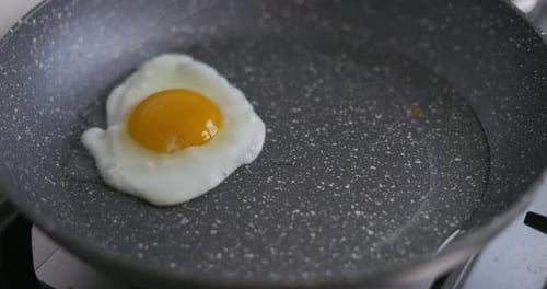 Eier in eine heiße Pfanne schlagen