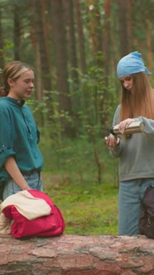 Sisters Share Warm Drink in Tranquil Forest