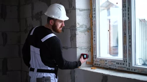 Builder using laser level in building on construction site. Construction worker installing and adjus