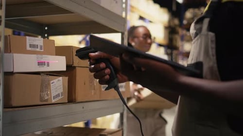 Gros plan d'un travailleur noir utilisant un lecteur de codes-barres pour traiter les étiquettes d'expédition