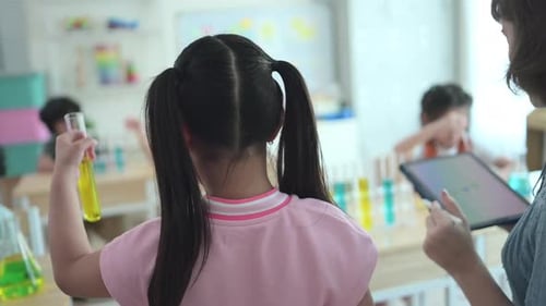 Teacher and students, Learn and experiment with science in a school science classroom.