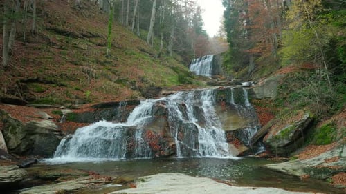 Beautiful cascading waterfall in an autumn forest. Pristine water cascading down mossy rocks in a
