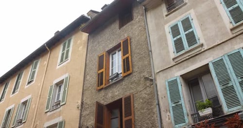 Colorful French townhouses with shutters and balconies create a charming European street view