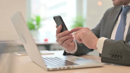 Gros plan d'un homme d'affaires travaillant sur un smartphone