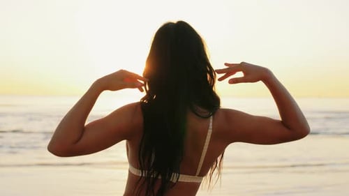Woman on Beach Stretching During Golden Hour Sunset