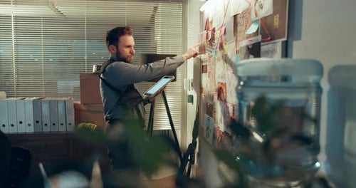 Detective Investigating Evidence with Digital Tablet in Office