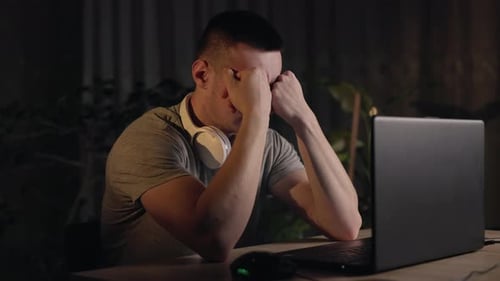 Tired Man Working on Laptop Late at Night