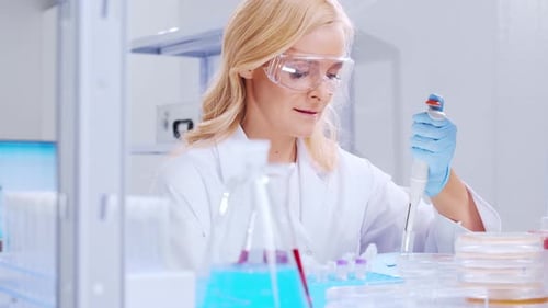 Woman Scientist Pipetting Samples in Modern Laboratory