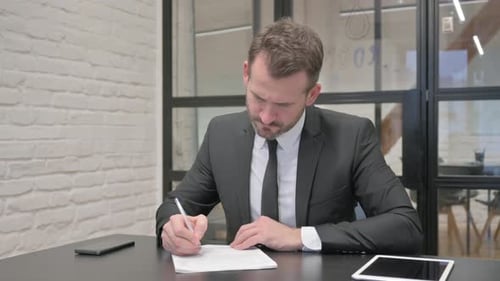 Man Signing Contract in Modern Office