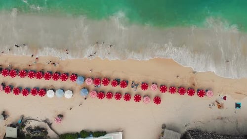 Top Aerial View on Sandy Ocean Shore with Resting Tourists and Beach Umbrellas Turquoise Water in