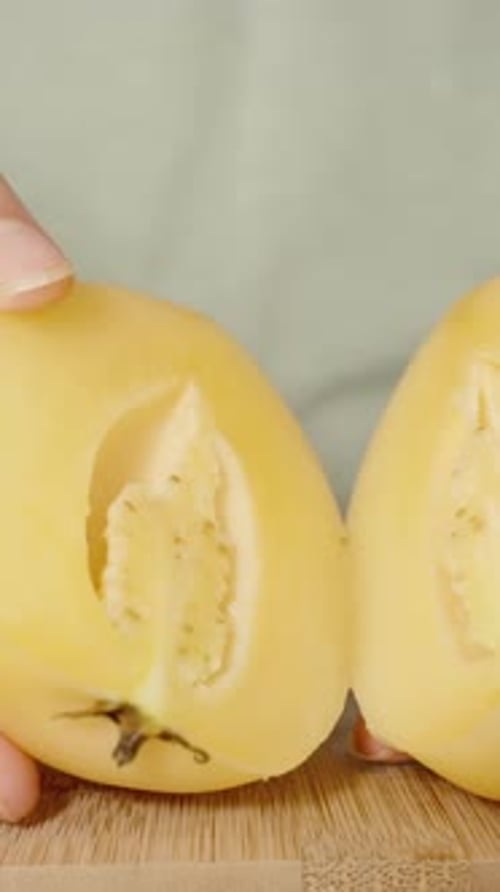 Vertical video. Close-Up of Pepino Inside, Seeds Between Two Halves Shown by Woman in Close-Up.